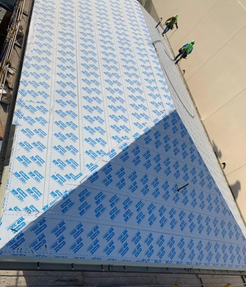 Professional roofers installing underlayment on a metal roof in Middletown